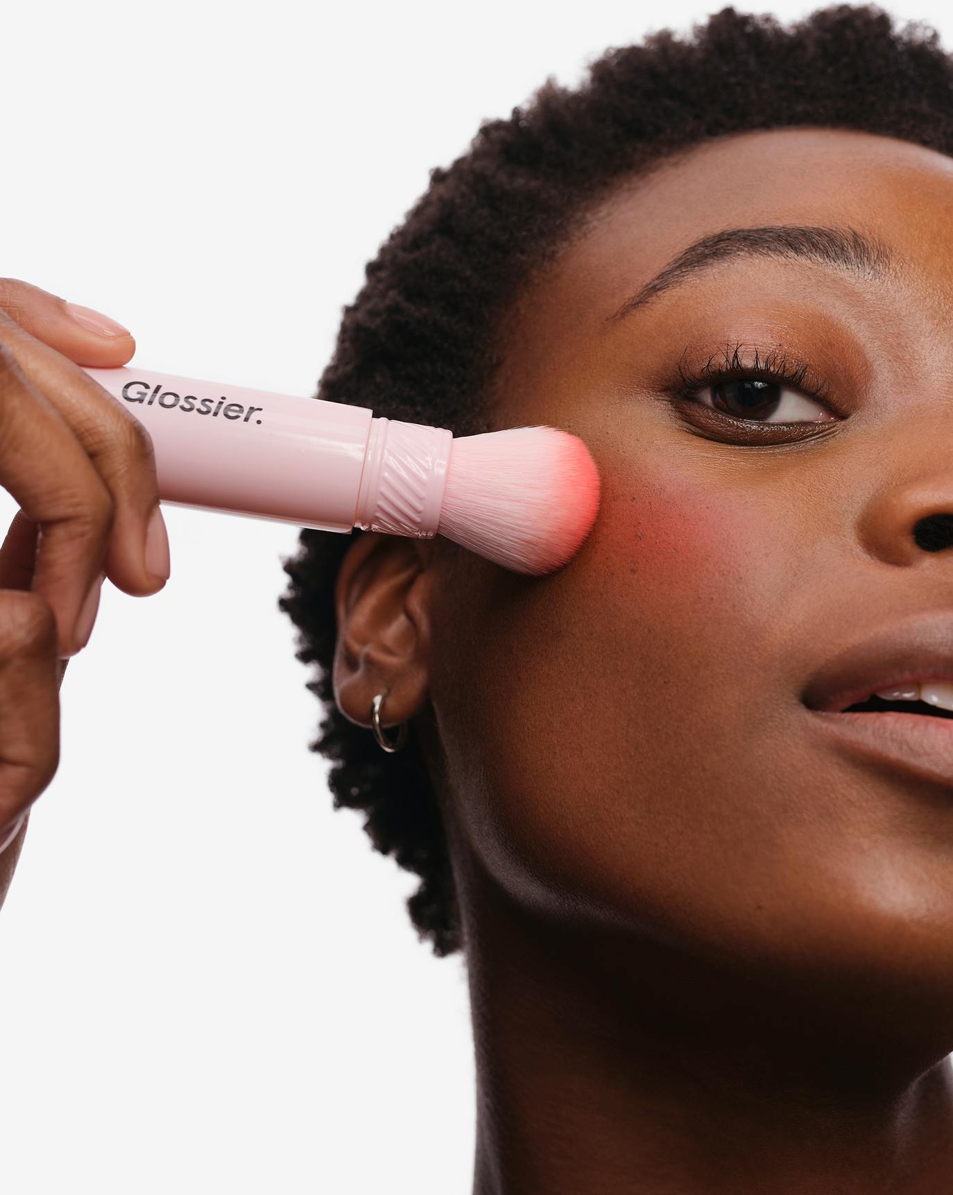 Olivia applies Cloud Paint Plush Blush in Burst.